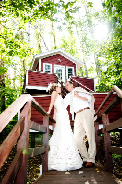 Bride and groom standing at the stairs of the tree house.