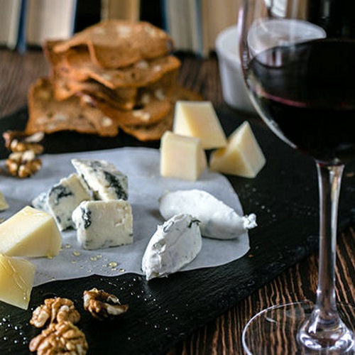Cheese board with crackers and a glass of red wine.