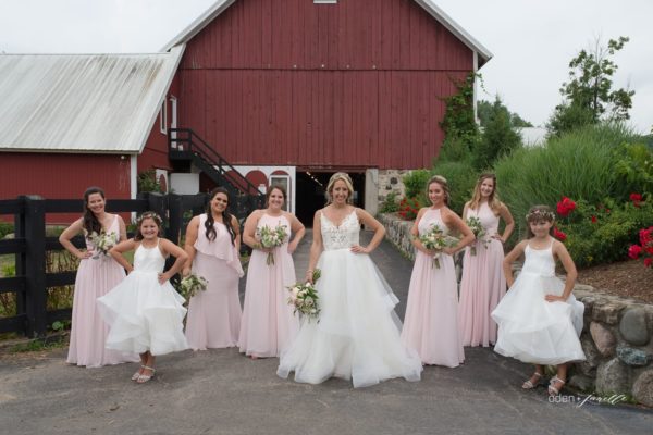 A bridal party standing in front of the barns at the stables at Black Star Farms.