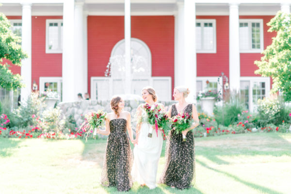 A bride and her two bridesmaids in front of the fountain an the Inn at Black Star Farms.