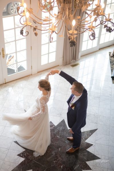 Groom spinning his bride on the star in the foyer.