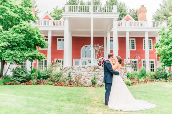 Wedding couple standing in the lawn in front of the Inn at Black Star Farms.