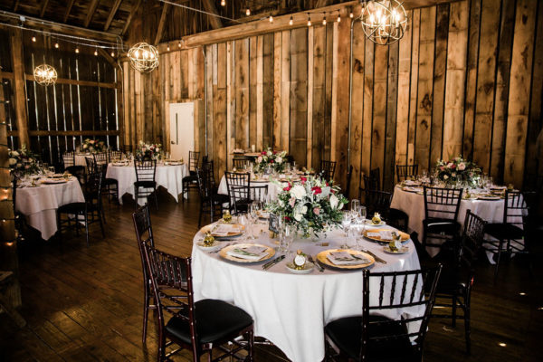 Round tables set for a wedding reception in the Pegasus Barn.