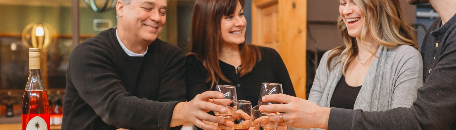 Couples raising glasses to cheers during a wine tasting at Black Star Farms Suttons Bay.