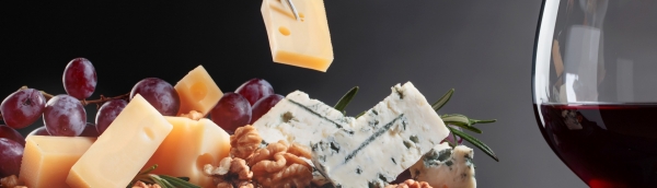 Image of a cheese board with a glass of red wine.
