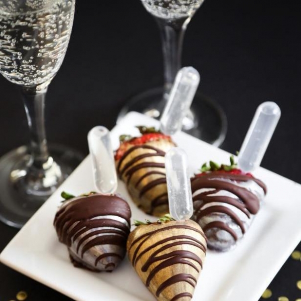 Chocolate covered strawberries with glasses of sparkling wine.