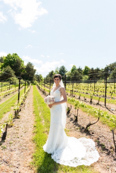 Bride standing in the vineyard during early summer.