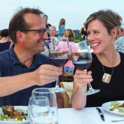 Couple clinking glasses at a wine dinner in our vineyard.