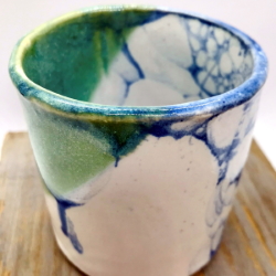 An exam[le of a bubble glazed pottery cup with blue and green colors.