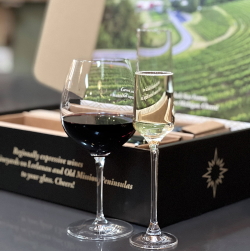 Glasses of wine in front of the branded gift box.